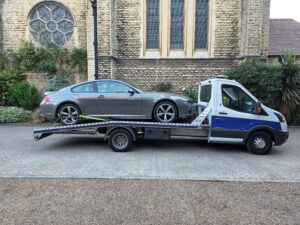 Grey BMW 6 Series Coupe loaded on a flatbed tow truck during a professional car collection service in Chiswick W4.